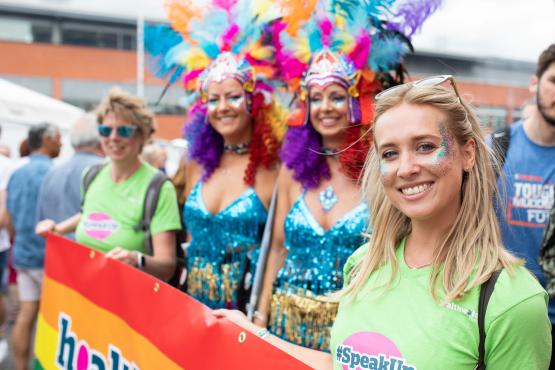 Four women at a pride event with multicoloured face paints